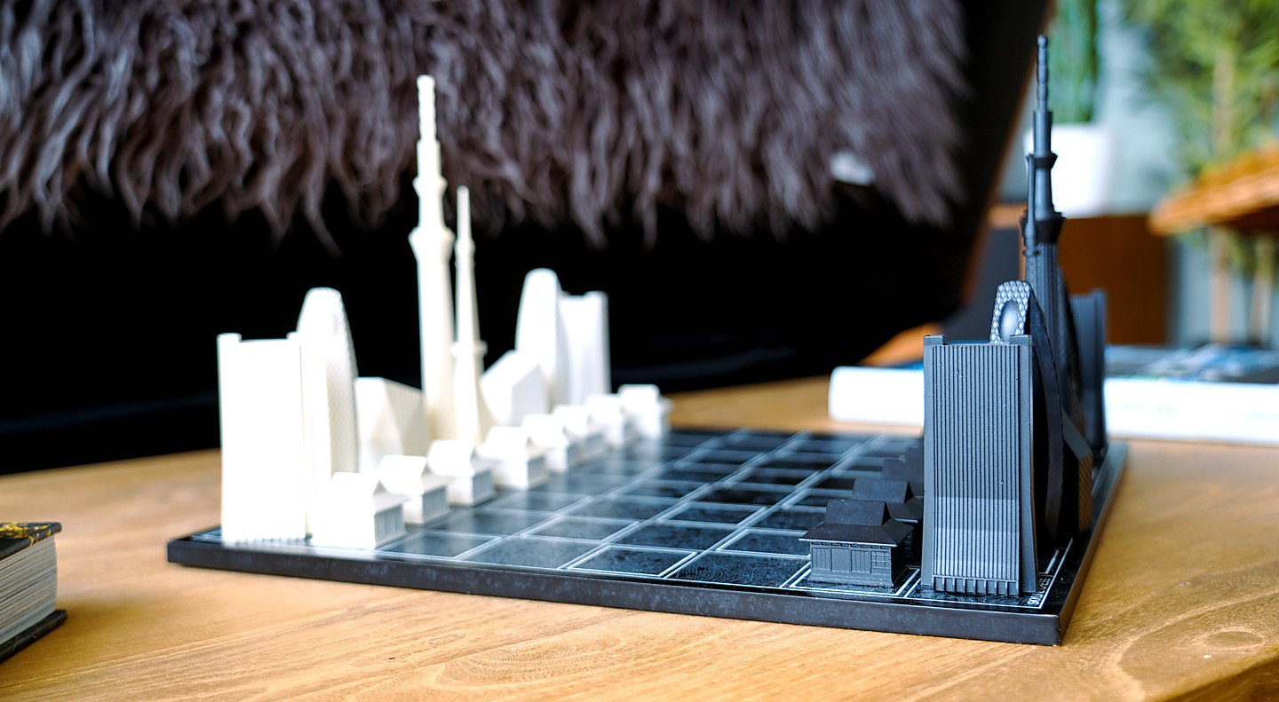 A skyline chess set on the living room table, black and white towers facing each other